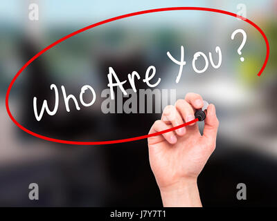 Man Hand writing Who Are You with black marker on visual screen. Isolated on office. Business, technology, internet concept. Stock Image Stock Photo