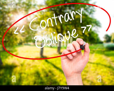 Man Hand writing Contrary - Oblique with black marker on visual screen. Isolated on background. Business, technology, internet concept. Stock Photo Stock Photo