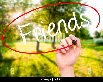 Man Hand writing Friends with black marker on visual screen. Isolated on background. Business, technology, internet concept. Stock Photo Stock Photo
