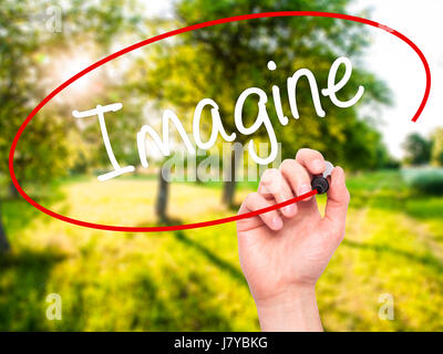 Man Hand writing Imagine  with black marker on visual screen. Isolated on background. Business, technology, internet concept. Stock Photo Stock Photo