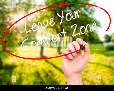 Man Hand writing Leave Your Comfort Zone with black marker on visual screen. Isolated on nature. Business, technology, internet concept. Stock Photo Stock Photo