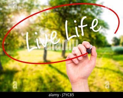 Man Hand writing Live Life with black marker on visual screen. Isolated on background. Business, technology, internet concept. Stock Photo Stock Photo