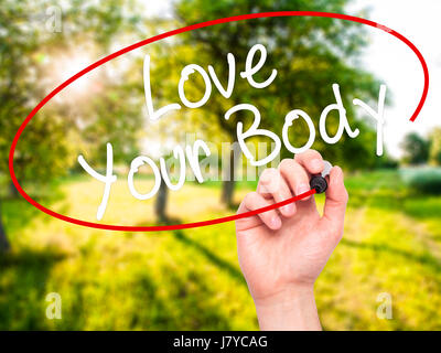 Man Hand writing Love Your Body with black marker on visual screen. Isolated on nature. Business, technology, internet concept. Stock Image Stock Photo