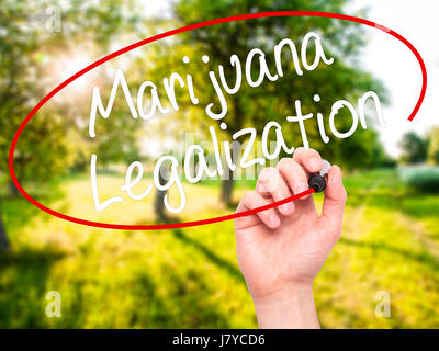 Man Hand writing Marijuana Legalization with black marker on visual screen. Isolated on nature. Live, technology, internet concept. Stock Photo Stock Photo