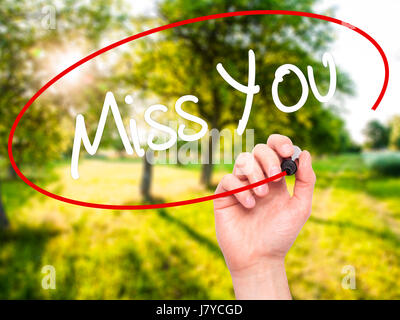 Man Hand writing Miss You with black marker on visual screen. Isolated on background. Business,  technology, internet concept. Stock Photo Stock Photo