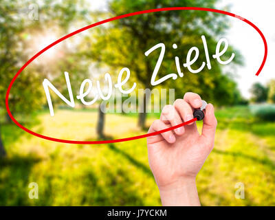 Man Hand writing Neue Ziele (New Goals in German)  with black marker on visual screen. Isolated on nature. Business, technology, internet concept. Sto Stock Photo
