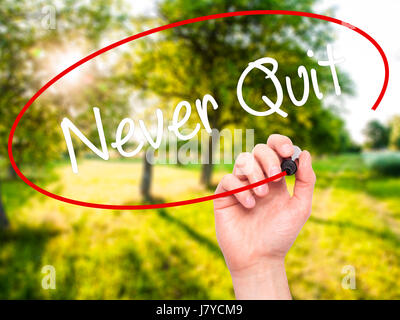 Man Hand writing Never Quit with black marker on visual screen. Isolated on background. Business, technology, internet concept. Stock  Photo Stock Photo