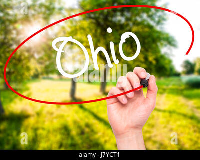 Man Hand writing Ohio  with black marker on visual screen. Isolated on background. Business, technology, internet concept. Stock Photo Stock Photo