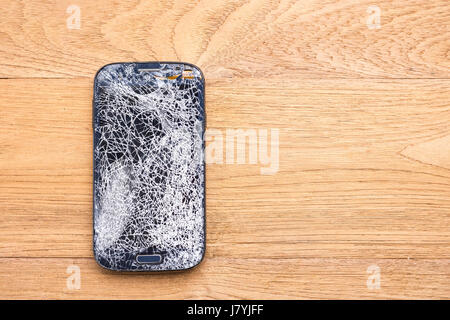 Top view broken of black smart phone on wooden table background Stock Photo
