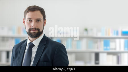 Successful confident businessman posing in his office and looking at camera Stock Photo