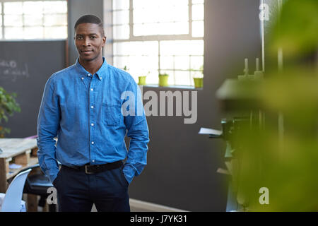 Focused African businessman standing in a modern office Stock Photo