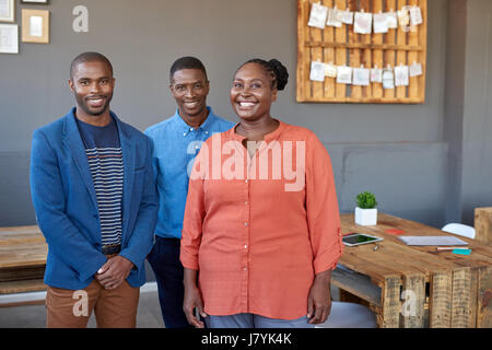 Smiling young African coworkers standing together in an office Stock Photo