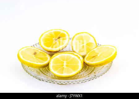 Crystal plate with sliced lemon slices isolated on white background Stock Photo