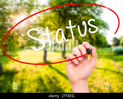Man Hand writing Status with black marker on visual screen. Isolated on background. Business, technology, internet concept. Stock Photo Stock Photo