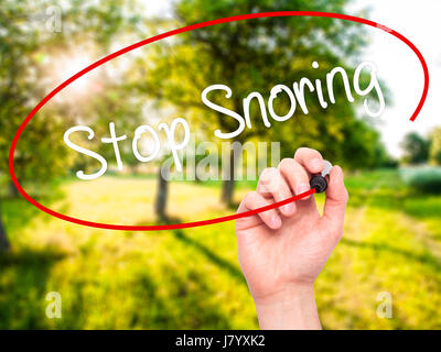 Man Hand writing Stop Snoring with black marker on visual screen. Isolated on nature. Business, technology, internet concept. Stock Photo Stock Photo