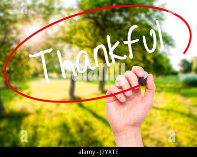 Man Hand writing Thankful  with black marker on visual screen. Isolated on background. Business, technology, internet concept. Stock Photo Stock Photo