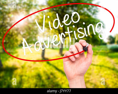 Man Hand writing Video Advertising with black marker on visual screen. Isolated on nature. Business, technology, internet concept. Stock Photo Stock Photo