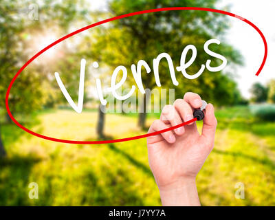 Man Hand writing Viernes (Friday in Spanish) with black marker on visual screen. Isolated on nature. Business, technology, internet concept. Stock Pho Stock Photo