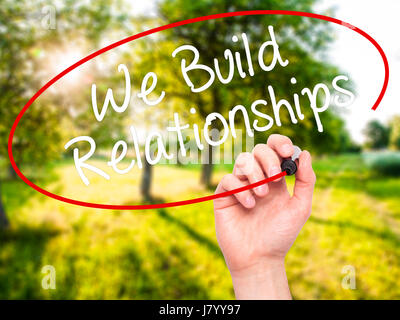 Man Hand writing We Build Relationships with black marker on visual screen. Isolated on nature. Business, technology, internet concept. Stock Photo Stock Photo