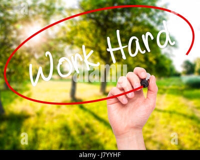 Man Hand writing Work Hard with black marker on visual screen. Isolated on background. Business, technology, internet concept. Stock Photo Stock Photo