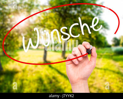 Man Hand writing Wunsche (Wishes in German) with black marker on visual screen. Isolated on background. Business, technology, internet concept. Stock  Stock Photo