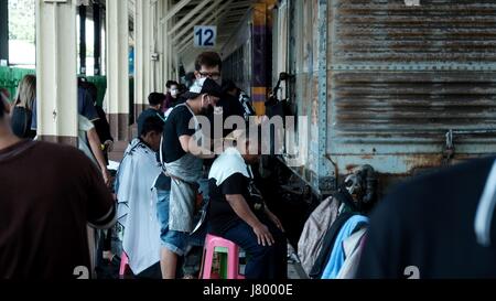 Outside Open Air Barber Shop on the Tracks At Hua Lamphong Bangkok Railway Station Stock Photo