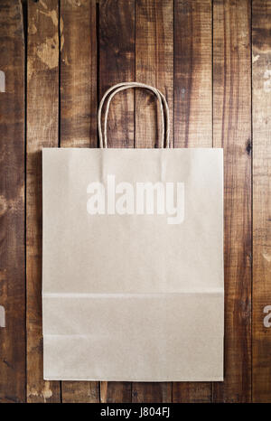 Recycled craft shopping bag on vintage wooden table background. Stock Photo