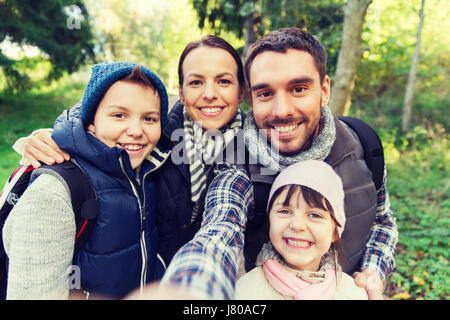 family with backpacks taking selfie and hiking Stock Photo