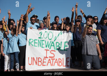 Young activists at the COP22 UN climate conference hold a sign reading '100% Renewable is Unbeatable' at a demonstration in Jemaa el-Fnaa, the central market plaza in Marrakech, Morocco, November 10, 2016.