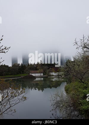 Apartment buildings by Humber Bay, Toronto, Ontario, Canada half covered by clouds and fog. The communities by the water look surreal. Stock Photo