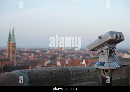 Installed binoculars on the Nuremberg Castle (Nürnberger Burg) with the skyline of Nuremberg in the early morning. Nuremberg, Bavaria, Germany Stock Photo