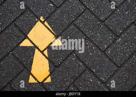 Yellow arrow paint on black brick concrete background Stock Photo