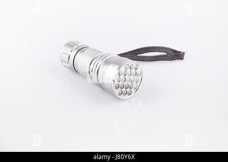 Silver LED flashlight on a white surface. Flashlight isolated on white background. Stock Photo