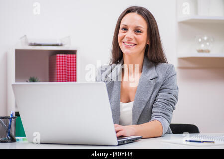 Young happy businesswoman is working in her office. Stock Photo