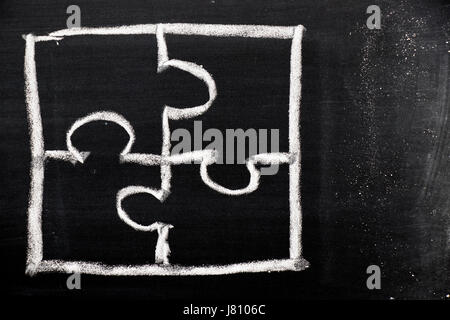 Chalk hand drawing as puzzle shape on black board background Stock Photo