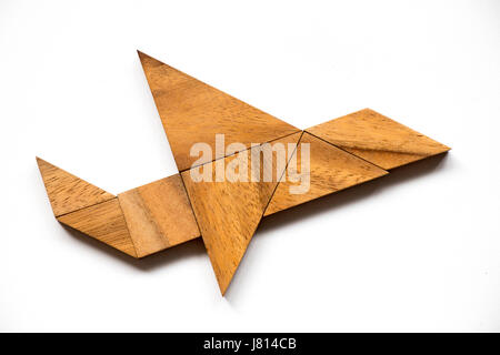 Wooden tangram puzzle in airplane shape on white background (Concept for new experience, start project) Stock Photo