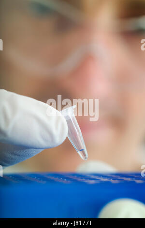 Loading a tube of DNA into a PCR (polymerase chain reaction ...