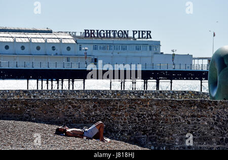 Brighton, UK. 26th May, 2017. A couple enjoy some early morning sunbathing on Brighton beach with today forecast to be the hottest day of the year so far with temperatures reaching the high 20s celsius in some parts of Britain Credit: Simon Dack/Alamy Live News Stock Photo