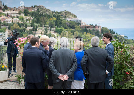 Taormina, Italy. 26th May, 2017. HANDOUT - European Union (EU) Council President Donald Tusk (concealed, L-R), French President Emmanuel Macron, US President Donald Trump, British Prime Minister Theresa May, EU Commission President Jean-Claude Juncker, German Chancellor Angela Merkel, Japan's Prime Minister Shinzo Abe, Italy's Prime Minister Paolo Gentiloni and Canada's Prime Minister Justin Trudeau standing by the coast at the G7 summit in Taormina, Italy, 26 May 2017. Credit: dpa/Alamy Live News Stock Photo