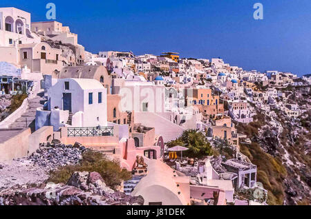 Oia, Santorini, Greece. 24th May, 2017. The picturesque village of Oia, Santorini, whose whitewashed and pastel-colored buildings and churches, seemingly stacked on top of each other, are perched on the steep edge of the caldera cliffs, with views of the sea, The southernmost member of the Cyclades island group, colorful Santorini is a favorite tourist and cruise ship destination. Credit: Arnold Drapkin/ZUMA Wire/Alamy Live News Stock Photo
