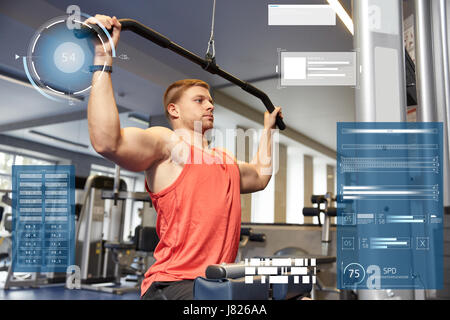 man flexing muscles on cable machine gym Stock Photo