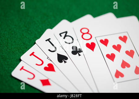 poker hand of playing cards on green casino cloth Stock Photo