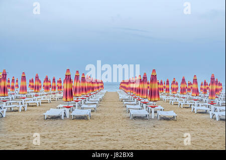 ALBENA, BULGARIA - JUNE 13, 2016. The Black Sea shore. blue sea water, clouds sunset sky, beach sand with umbrellas and sunbeds Stock Photo