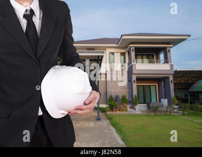 engineer holding helmet with modern house background Stock Photo