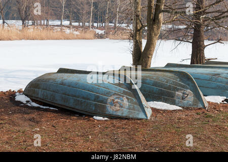 inverted boats on the frozen lake Stock Photo