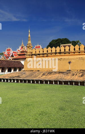 Pha That Luang large gold-covered stupa with Hor Dhammasabha hall on background. At 4 km.from city center-legend dates it in 3rd.century BC-actual for Stock Photo