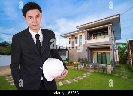 engineer holding helmet with modern house background Stock Photo