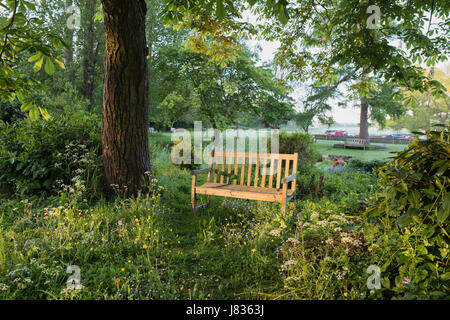 Wooden bench in the grounds of the Country inn, Lower Slaughter, Cotswolds, Gloucestershire, UK. Selective focus Stock Photo