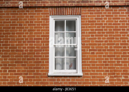 White vintage wooden window on a restored red brick wall Stock Photo