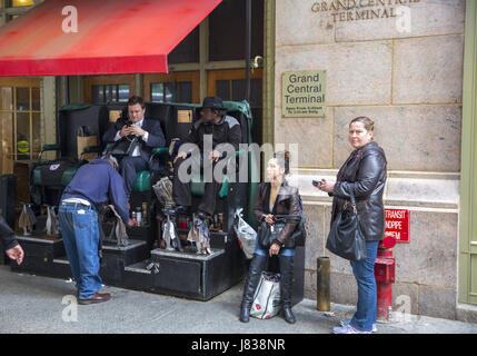 Shoeshine man has a prime location for his business at the entrance to Greand Central Terminal on 42nd  Street in Manhattan, NYC. Stock Photo